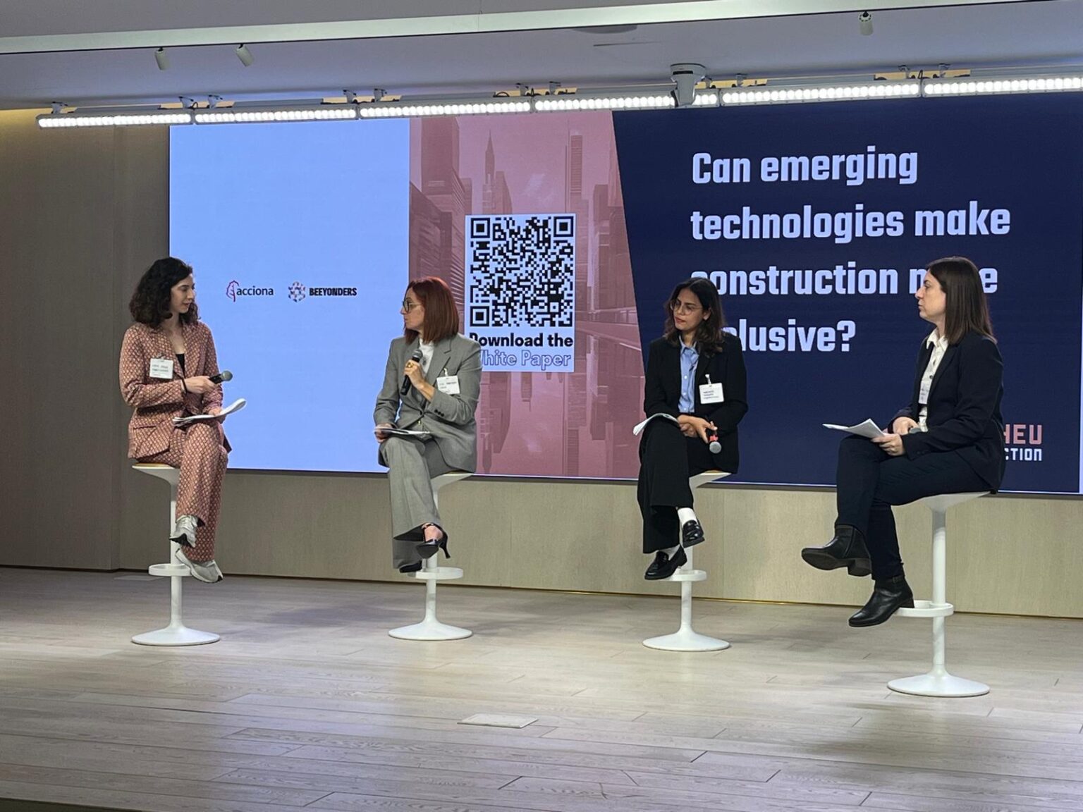 women sitting on stage at an event